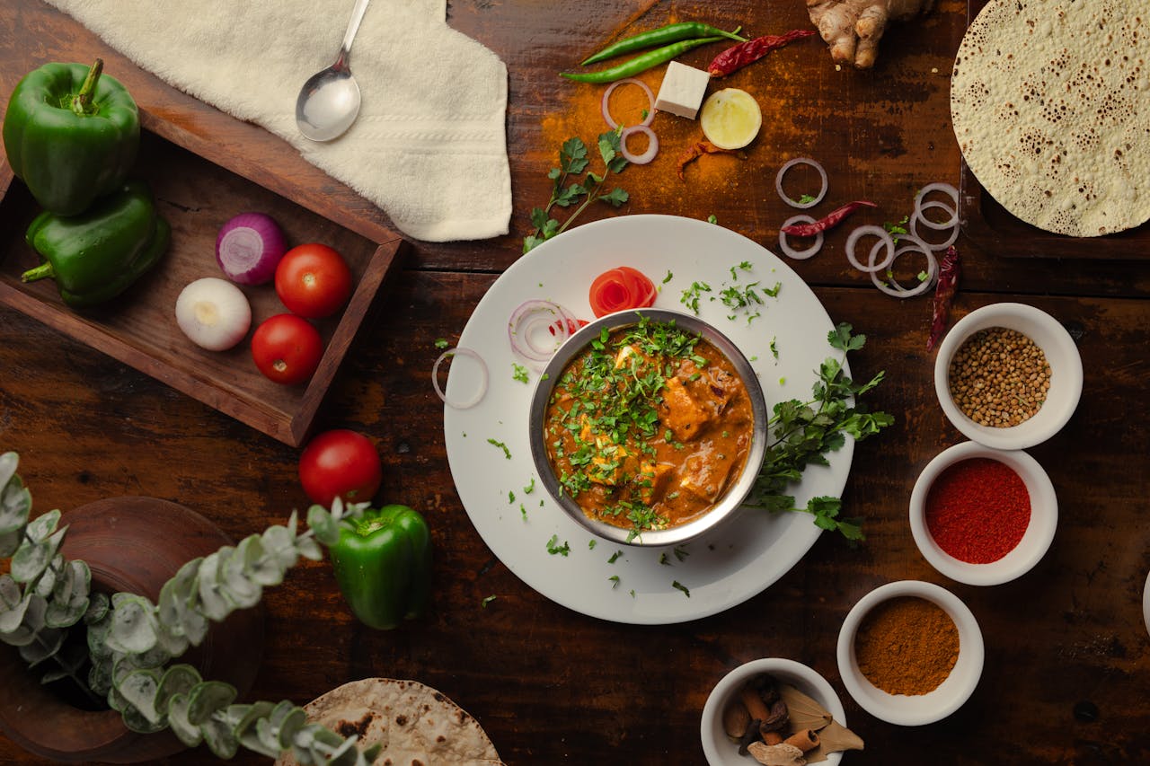 Vibrant array of spices including turmeric, cumin, and chili arranged on a dark surface.